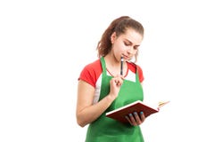 Magasinier de femme d'Â ou travailleur au détail pensant et tenant l'ordre du jour photographie stock Magasinier de femme d'Â ou travailleur au détail pensant et tenant l'ordre du jour photographie stock